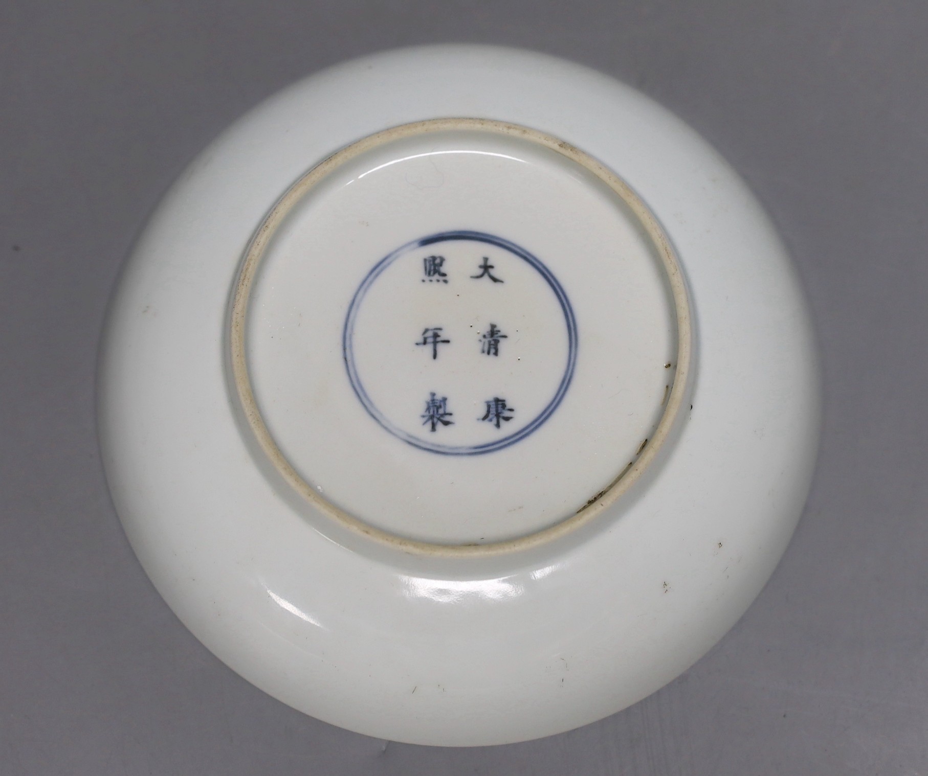 A Chinese blue and white saucer dish, Kangxi mark but later, 16cm diameter